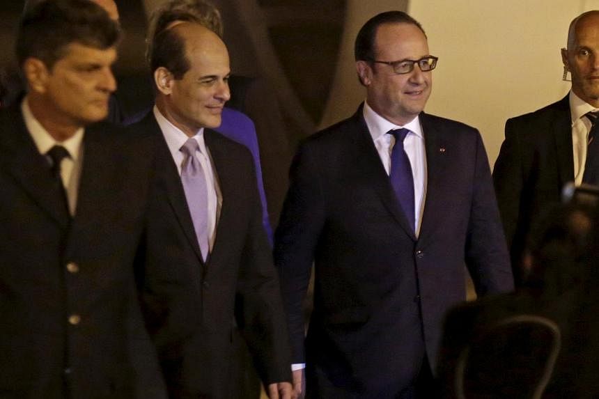 French President Francois Hollande (second from right) walks next to Cuba's Deputy Foreign Minister Rogelio Sierra (second from left) at Havana's Jose Marti airport on May 10, 2015. Mr Hollande is the first French president to visit Cuba in more than