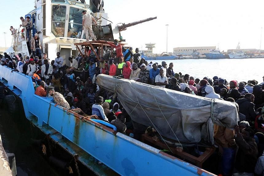 A Libyan coastguard boat carrying mostly African migrants arrive at the port in the city of Misrata on May 3, 2015, after the coastguard intercepted five boats carrying around 500 people trying to reach Europe. -- PHOTO: AFP