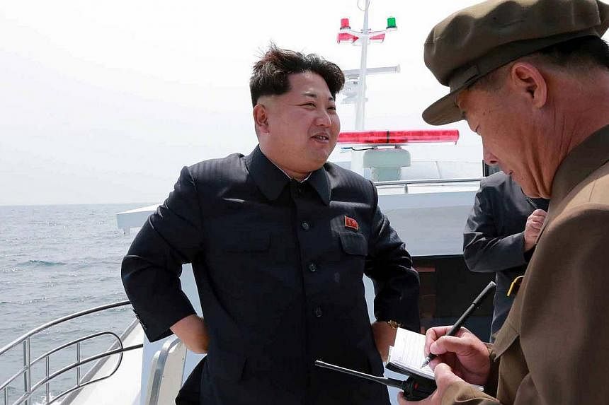 This undated picture released from North Korea's official Korean Central News Agency (KCNA) on May 9, 2015, shows the country's leader Kim Jong-Un smiling while observing an underwater test-fire of a submarine-launched ballistic missile at an undiscl