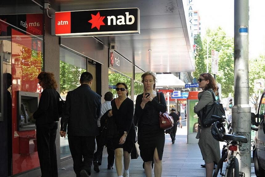 People walking past and queueing at the National Australia Bank (NAB) ATM machine. -- PHOTO: BLOOMBERG
