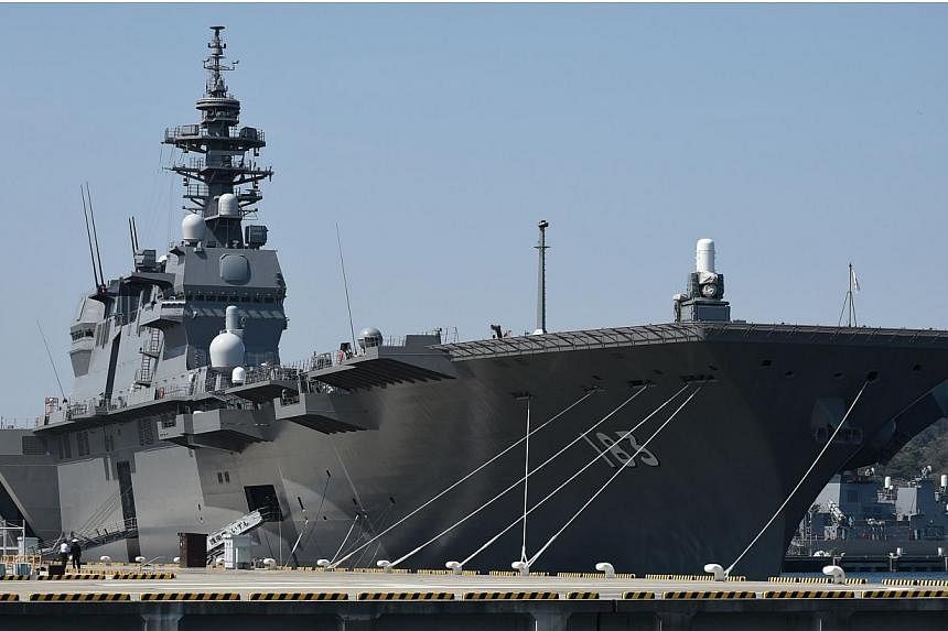 The Japan Maritime Self Defence Force helicopter destroyer Izumo sits at anchor at Yokosuka base in Yokosuka on March 31, 2015.&nbsp;Japanese ruling party officials signed off on bills on Monday, May 11, to implement a drastic change in security poli