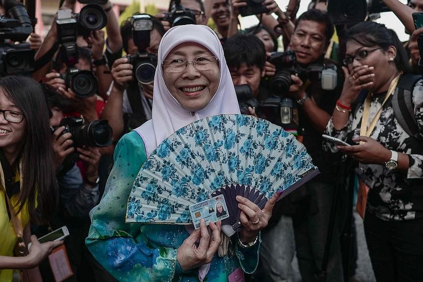 Parti Keadilan Rakyat (PKR) president&nbsp;Wan Azizah Wan Ismail&nbsp;(centre), wife of Malaysian opposition leader Anwar Ibrahim, arrives at a polling station during a by-election in Permatang Pauh, in the northern Malaysian state of Penang on March