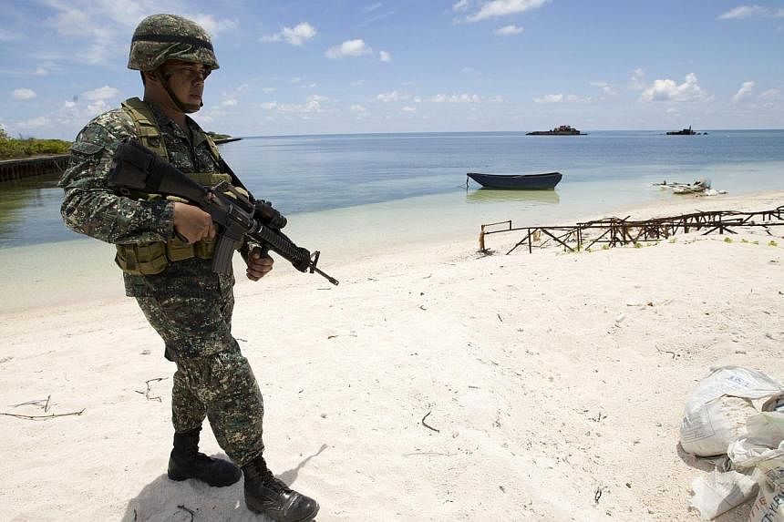 A Filipino soldier patrols at the shore of Pagasa island (Thitu Island) in the Spratly group of islands in the South China Sea, west of Palawan, Philippines on May 11, 2015. -- PHOTO: EPA&nbsp;