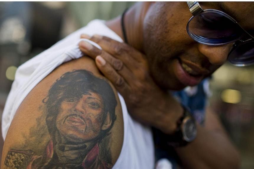 Prince fan Ash poses with his Prince tattoo before entering a "Rally 4 Peace" concert in Baltimore, Maryland on May 10, 2015. -- PHOTO: AFP