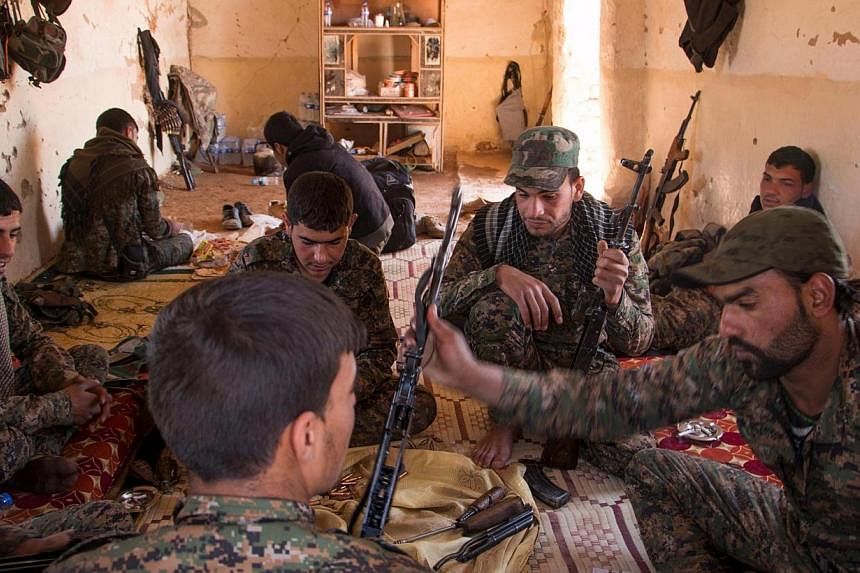 Kurdish People's Protection Units (YPG) fighters clean their weapons inside a safehouse after what they said were clashes with ISIS fighters in the southern countryside of Ras al-Ain on May 8. -- PHOTO: REUTERS