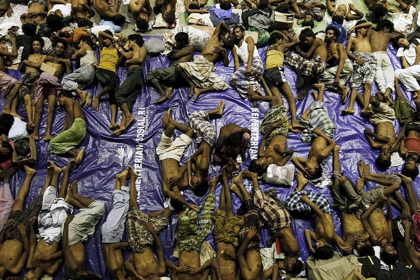 Migrants believed to be Rohingya rest inside a shelter after being rescued from boats at Lhoksukon in Indonesia's Aceh Province May 11, 2015. -- PHOTO: REUTERS