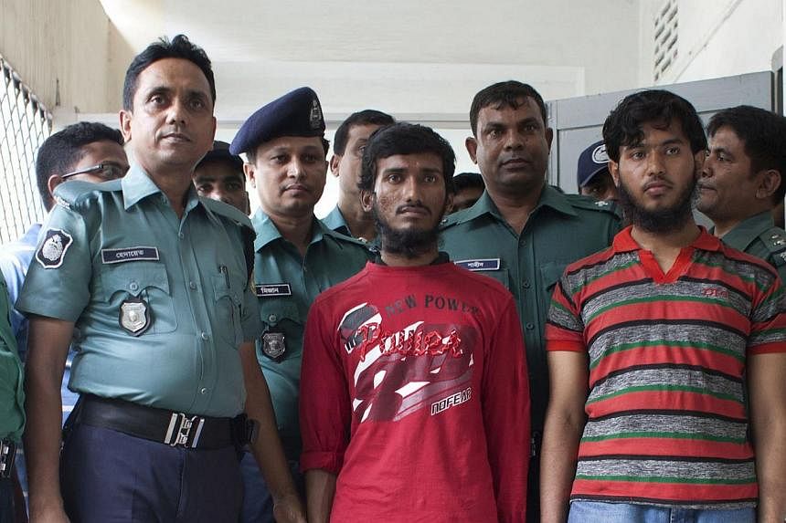 Bangladesh police with two men (right) suspected of attacking and killing blogger Washiqur Rahman in Dhaka on March 30, 2015. A masked gang wielding machetes hacked another blogger to death on Tuesday in north-eastern Bangladesh in the third such dea