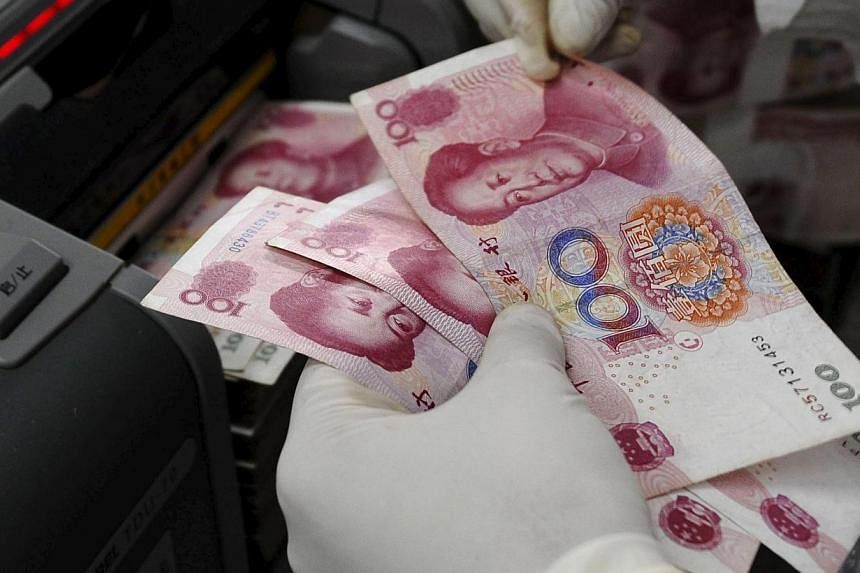 An employee counting Renminbi (RMB) banknotes at a branch of Bank of China in Changzhi, Shanxi province. -- PHOTO: REUTERS&nbsp;