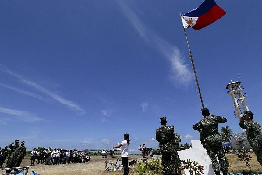 Filipino residents and soldiers conduct a flag raising ceremony during the visit of Philippines military chief General Gregorio Catapang Junior in Pagasa Island (Thitu Island) at the Spratly group of islands in the South China Sea, west of Palawan, o