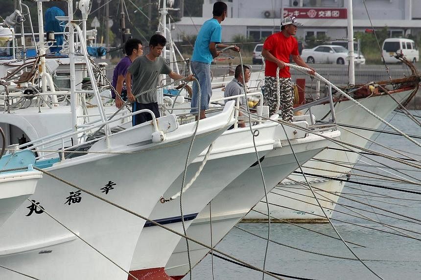 Fishermen tying up their vessels in preparation for Typhoon Noul at a fishing port in Itoman, Okinawa, on May 11, 2015. -- PHOTO: EPA