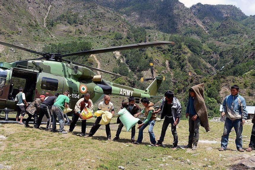 Nepalese villagers receiving relief materials from an Indian army helicopter at Bhogteni village in Gorkha on May 4, 2015. -- PHOTO: AFP&nbsp;