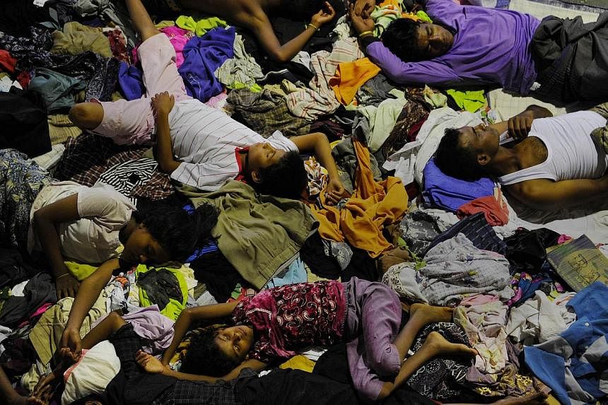 A group of rescued migrants from Myanmar and Bangladesh sleeping at a government sports auditorium in Lhoksukon, Aceh province, on May 12, 2015, after Indonesian rescuers found their boat carrying 573 passenger stranded in waters off north Aceh provi