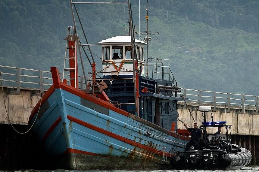 Malaysian Maritime police inspect one of the boats which carried illegal migrants in Langkawi on May 12, 2015. -- PHOTO: AFP