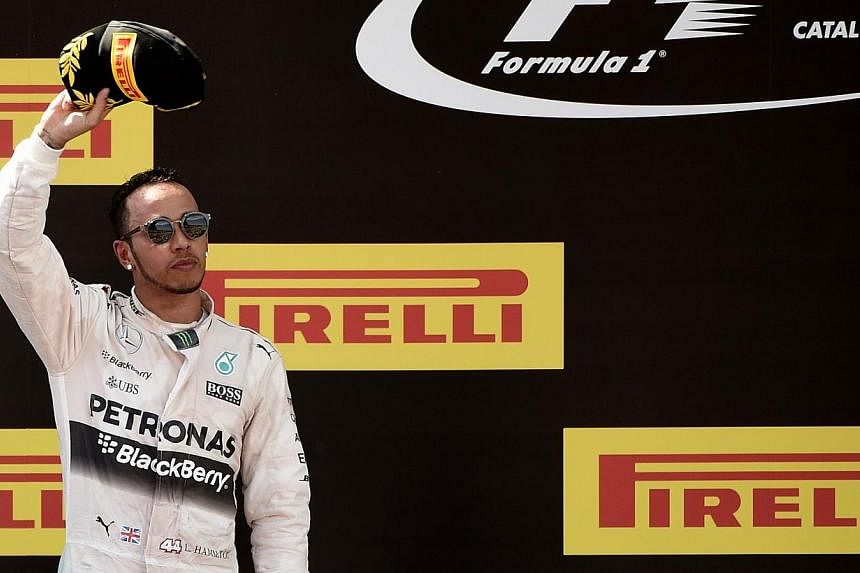 Mercedes AMG Petronas F1 Team's Lewis Hamilton celebrates on the podium after the Spanish Formula One Grand Prix on May 10, 2015 at the Circuit de Catalunya in Montmelo on the outskirts of Barcelona. The British driver's long-awaited new deal with Me