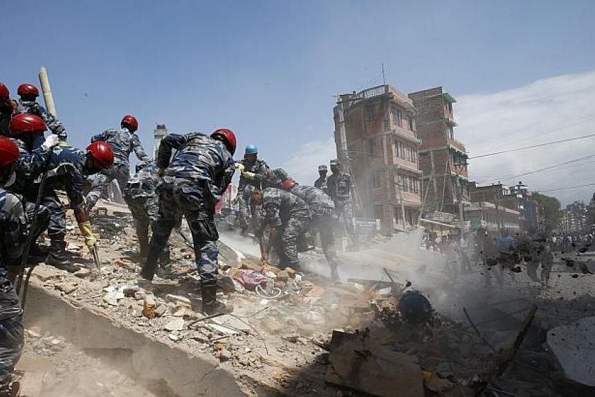 Nepalese armed police force search for victims after a house collapsed when a strong earthquake hit Kathmandu, Nepal on May 12, 2015. -- PHOTO: EPA&nbsp;
