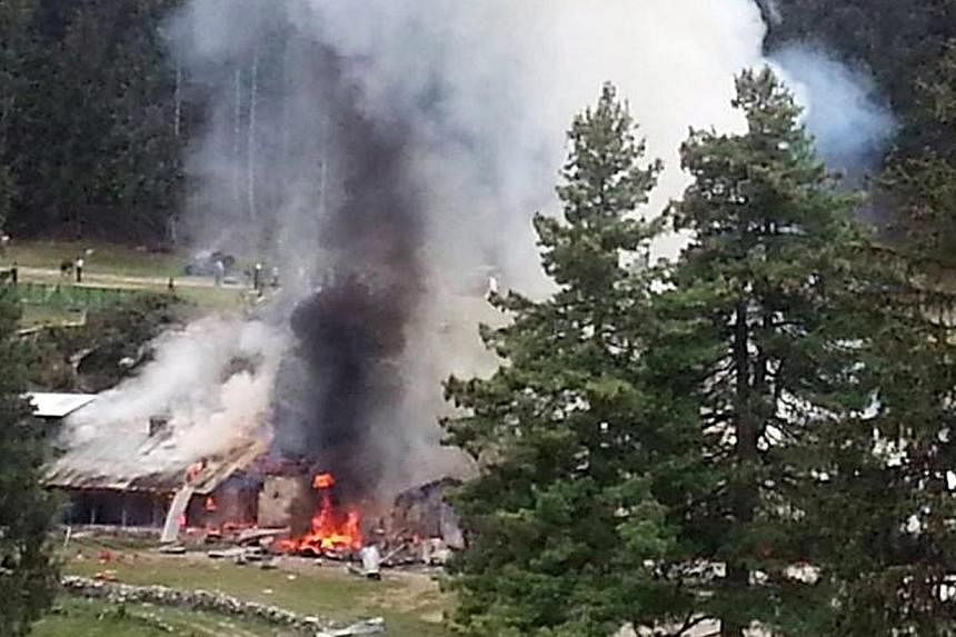 Smoke billows from the scene of the helicopter crash at Naltar in Gilgit, Pakistan on Friday that killed the ambassadors of Norway and the Philippines as well as the wives of the Indonesian and Malaysian envoys. -- PHOTO: EPA