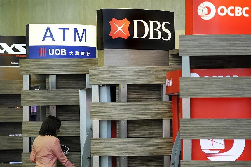 A customer using a DBS automated teller machine (ATM), standing between the ATMs of UOB and OCBC, at Changi Airport. Credit rating agency Moody's Investors Service says a number of differences among Singapore's three biggest lenders could lead to the