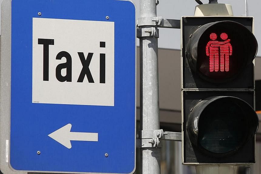 A new traffic light (right), showing a same-sex couple, is pictured next to a taxi sign on May 12, 2015, in Vienna. -- PHOTO: AFP &nbsp;