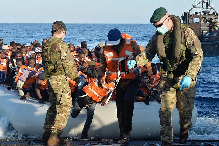 A handout image made available by the British Ministry of Defence (MOD) of Royal Marines leading migrants to safety on a Landing Craft of HMS Bulwark from an inflatable boat on the Mediterraean&nbsp;on May 13,&nbsp;2015.&nbsp;The EU rejected on Wedne
