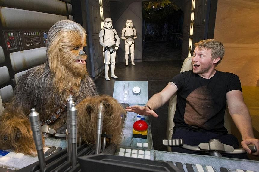 A fan poses by the wax figure of Star Wars character Chewbacca at the Star Wars At Madame Tussauds attraction in London on May 12, 2015. -- PHOTO: AFP&nbsp;