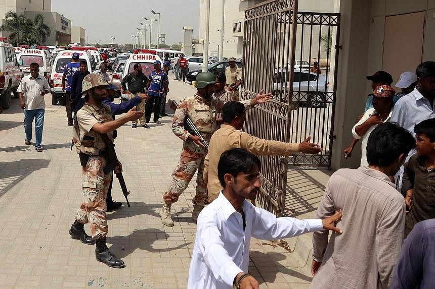 Pakistani rangers stand guard outside a hospital where injured victims of target killing are brought to hospital in Karachi, Pakistan on May 13, 2015. The Islamic State in iraq and Syria (ISIS) claimed responsibility for the attack that killed at lea