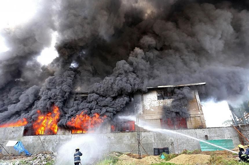 Firefighters working to put out a blaze at a plastic slipper factory in the suburb of Valenzuela in Manila, on Wednesday, May 13, 2015. The fire killed 31 workers, with dozens missing and feared dead, government and fire officials said.. -- PHOTO: AF