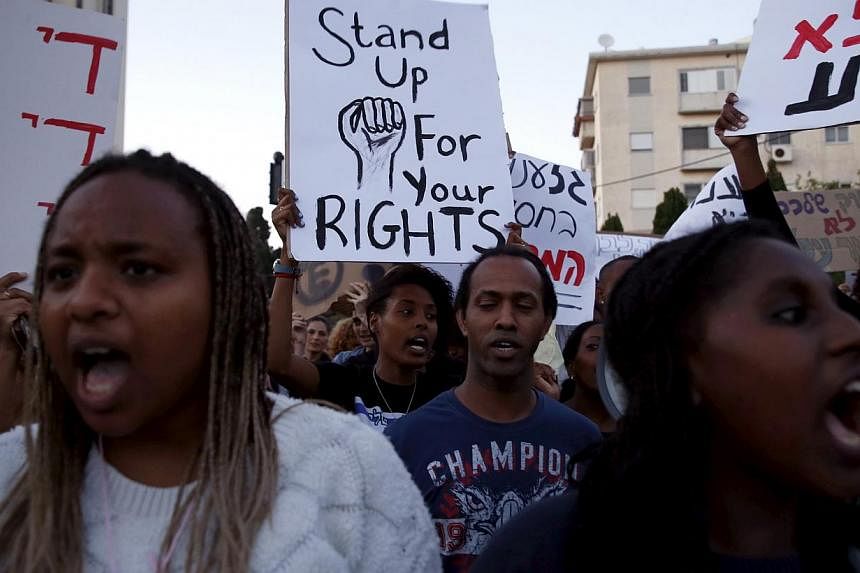 Israelis of Ethiopian descent hold signs during a protest against police brutality and racism in the northern city of Haifa, Israel May 12, 2015. -- PHOTO: REUTERS