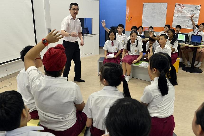 A teacher conducting a lesson with a class of Primary 6 pupils at Woodlands Primary School in 2012. Singapore has once again topped the biggest global school rankings published by the Organisation for Economic Co-operation and Development. -- PHOTO: 