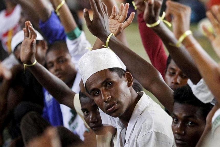 Migrants, believed to be Rohingya, raising their hands during an inspection at a shelter in Lhoksukon, in Indonesia's Aceh Province, on May 12, 2015. -- PHOTO: REUTERS