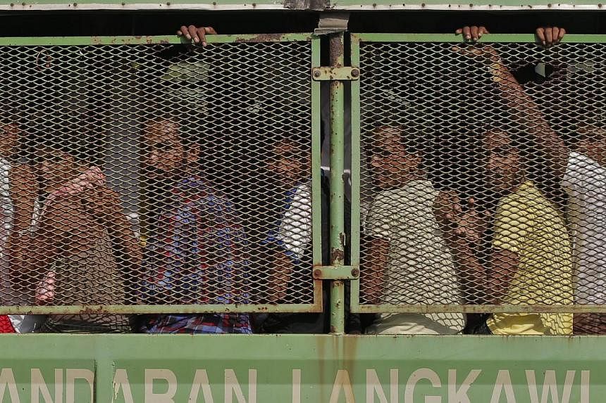 Bangladeshi and Rohingya migrants arriving in a truck at a naval base in Langkawi on May 14, 2015. More vessels bearing hungry migrants are headed towards Malaysia, which has beefed up sea and air patrols off its north-eastern coast to prevent them l