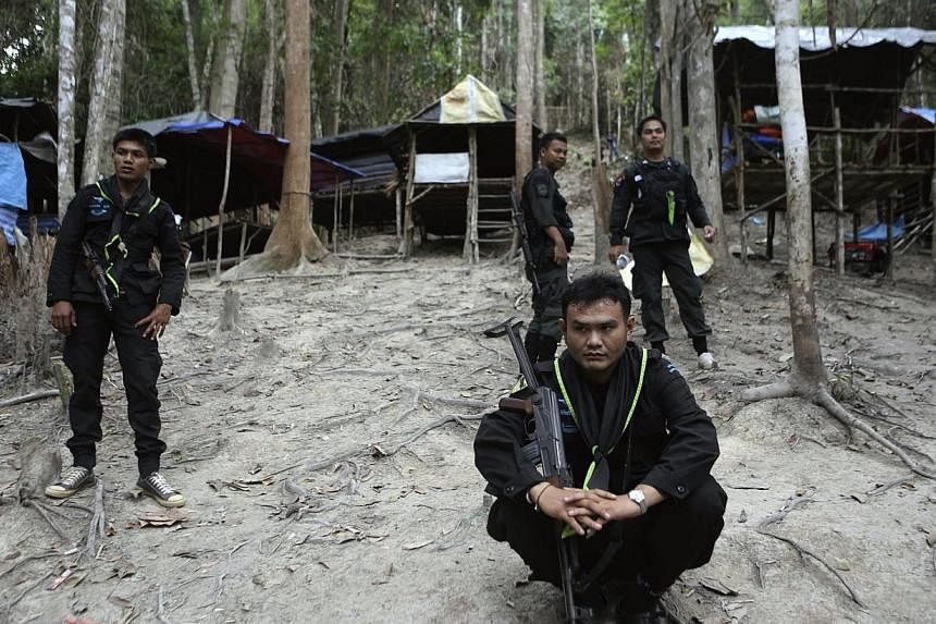 Thai soldiers securing an abandoned jungle camp believed to have been used by human traffickers to detain Rohingya migrants at a mountain in Sadao, Songkhla province, southern Thailand, on May 12, 2015. -- PHOTO: EPA&nbsp;