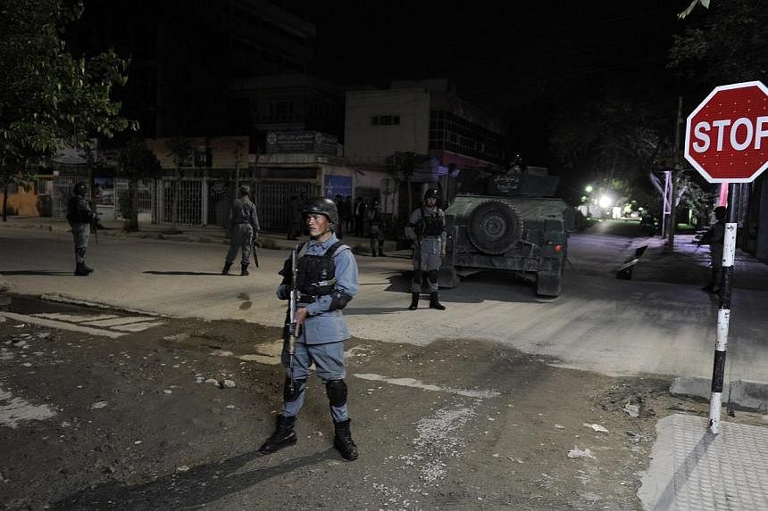 Afghan security officials secure the scene of a gunfight between militants and Government forces near a guest house in Kabul, Afghanistan on May 13, 2015. -- PHOTO: EPA