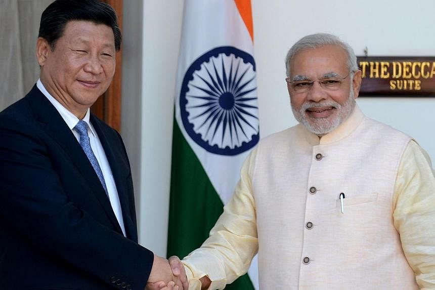 A&nbsp;September 2014 photo shows Indian Prime Minister Narendra Modi (right) shaking hands with Chinese President Xi Jinping during a meeting in New Delhi.&nbsp;Modi on Wednesday left for China on an official visit focused on boosting trade ties bet
