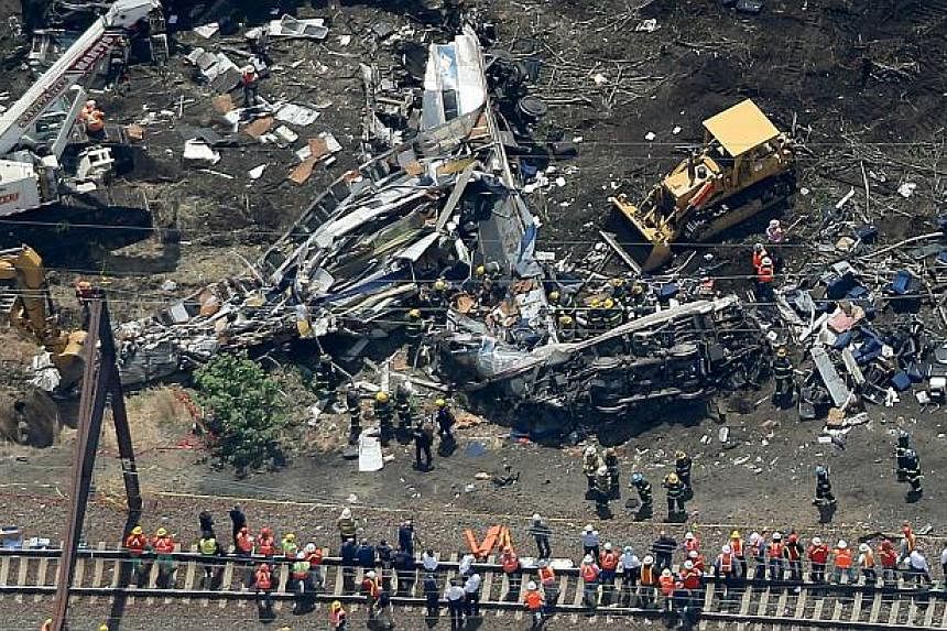 Investigators and first responders work near the wreckage of Amtrak train from Washington to New York that derailed yesterday May 13, 2015 in north Philadelphia, Pennsylvania. -- PHOTO: AFP