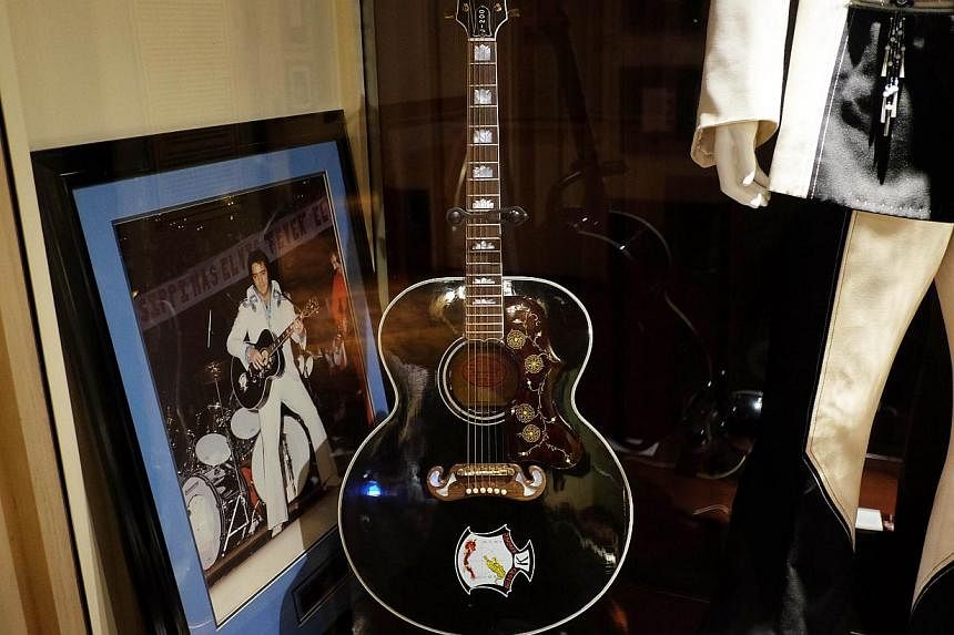 Elvis Presley's J-200 guitar and framed photograph on display at the Hard Rock Cafe in New York on May 11, 2015. The guitar is among the music memorabilia to be auctioned by Julien's Auctions on May 15 and 16 in New York. -- PHOTO: AFP