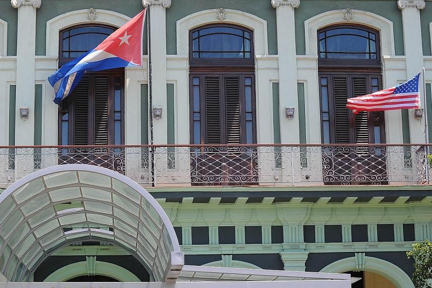 A Cuban and US flag on the balcony of a hotel in Havana on April 13, 2015. US and Cuban negotiators will meet next week to discuss the reopening of embassies in each other's capitals as part of efforts to restore diplomatic ties. -- PHOTO: AFP