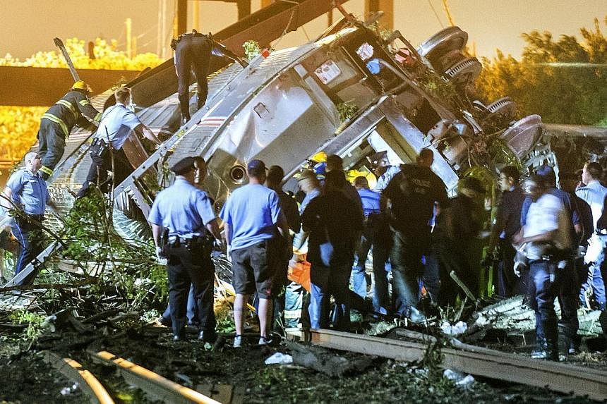 Rescue workers climbing into the wreckage of a crashed Amtrak train in Philadelphia, Pennsylvania on May 12, 2015. -- PHOTO: REUTERS