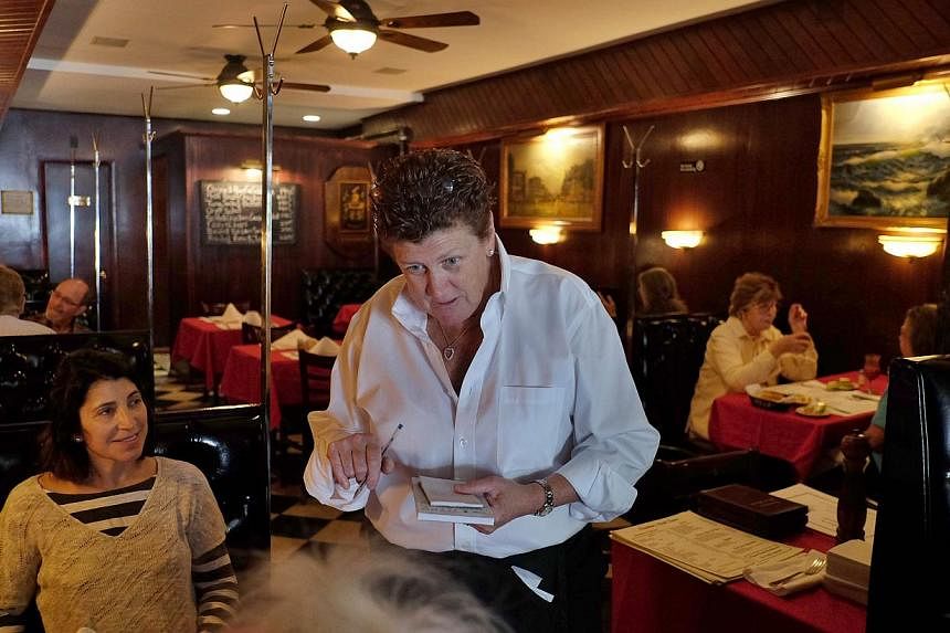 Maureen Donohue-Peters, a waitress at Donohue's Steak House, works in the restaurant in New York on May 14, 2014.&nbsp;Robert Ellsworth, an art collector and a regular to the restaurant who died at the age of 85 in August, left US$100,000 in his will