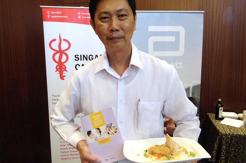 Mr Ricky Chiu, 61, posing with the Singapore Cancer Society's booklet with tips to help cancer patients eat right, and a sample of a meal suited to a cancer patient. Mr Chiu was diagnosed with throat cancer in 1997, but has since fully recovered. -- 
