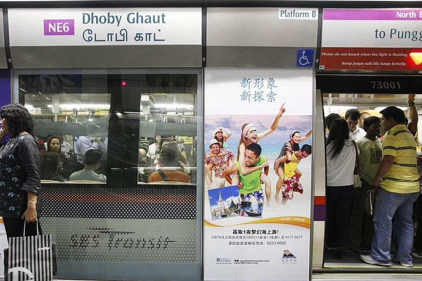 Commuters getting into a train at Dhoby Ghaut MRT station on the North-East Line (NEL). New trains on both the NEL and the Circle Line will be fitted with gap fillers. -- PHOTO: ST FILE