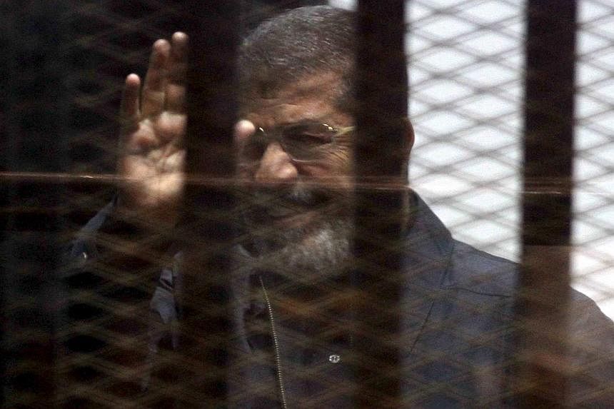 Ousted Egyptian president Mohamed Mursi is seen behind bars during his trial at a court in Cairo on April 30, 2015. -- PHOTO: REUTERS