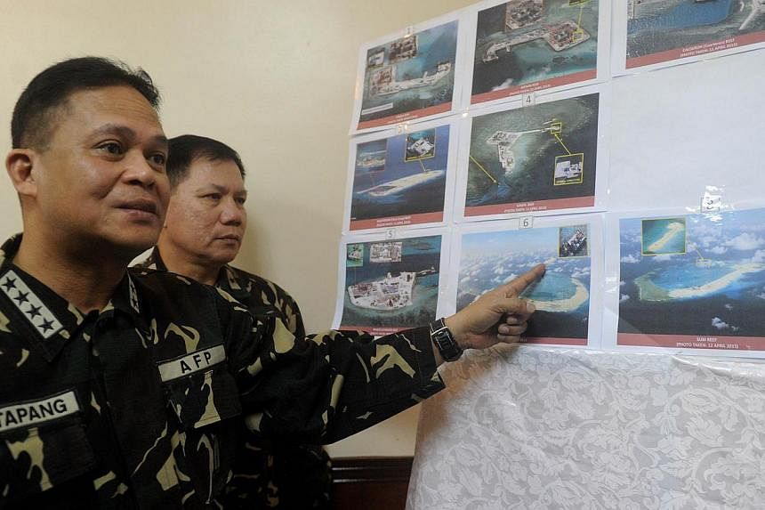 Filipino military chief Gregorio Catapang pointing to aerial photos of Chinese construction over reefs and shoals in the Spratly archipelago during a press briefing in Manila last month. The Philippines has expressed alarm about China's reclamation a