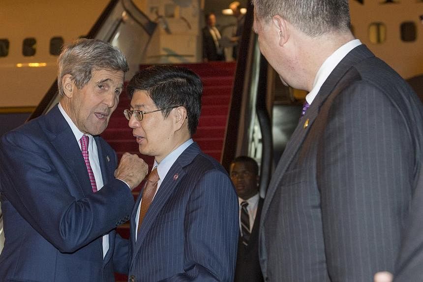 US Secretary of State John Kerry (left) speaking with Chinese Ministry of Foreign Affairs Director General Cong Peiwu as he disembarks from his plane upon arrival in Beijing on May 16, 2015. -- PHOTO: REUTERS