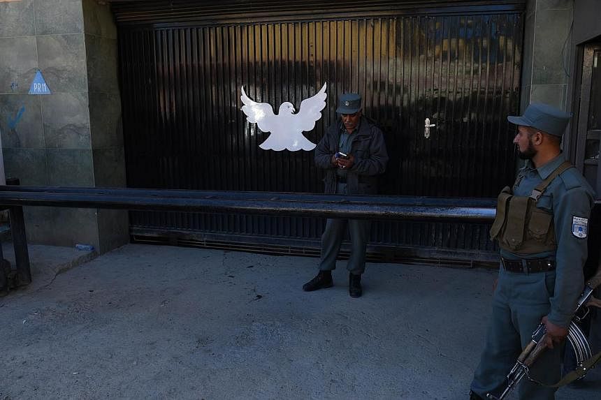 Afghan policemen stand guard at the entrance of the Park Palace guesthouse in Kabul on May 14, 2015. -- PHOTO: AFP&nbsp;