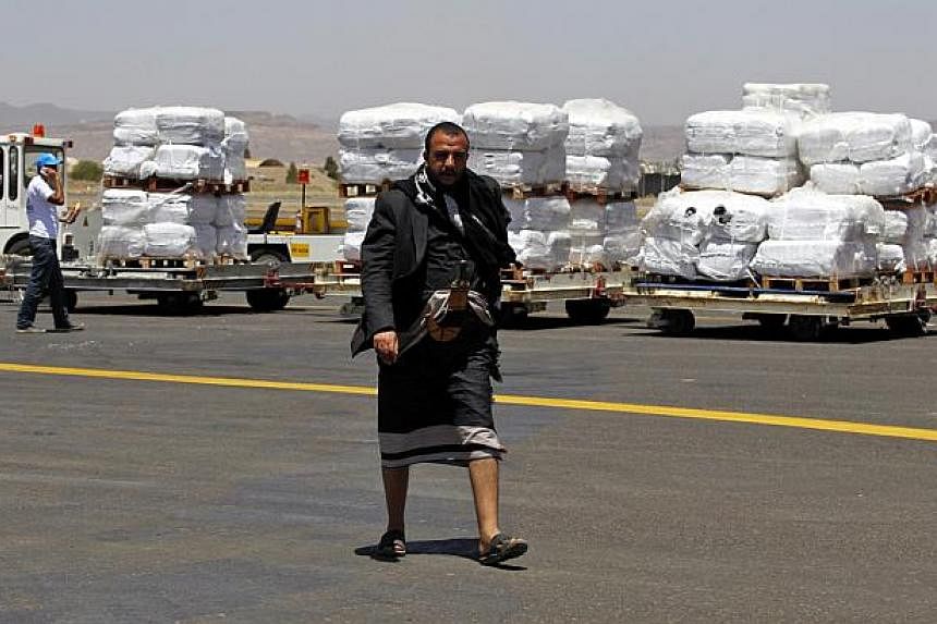 A Yemeni walks in front of emergency aid supplied by the United Nations High Commission for Refugees after it was unloaded at Sana’a International Airport, in Sana’a, Yemen, on May 16, 2015. -- PHOTO: EPA