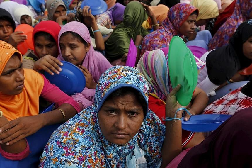 Rohingya migrants who arrived in Indonesia by boat wait for breakfast inside a temporary compound for refugee at Kuala Cangkoi village in Lhoksukon, Indonesia's Aceh Province, on May 17, 2015. -- PHOTO: REUTERS