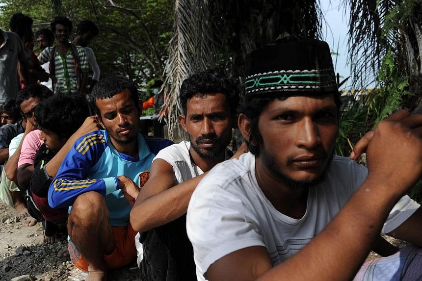 In this photograph taken on May 16, 2015, a group of rescued migrants from Bangladesh line up to be documented by Indonesian immigration personnel at the confinement area in the fishing port of Kuala Langsa in Aceh province where hundreds of migrants