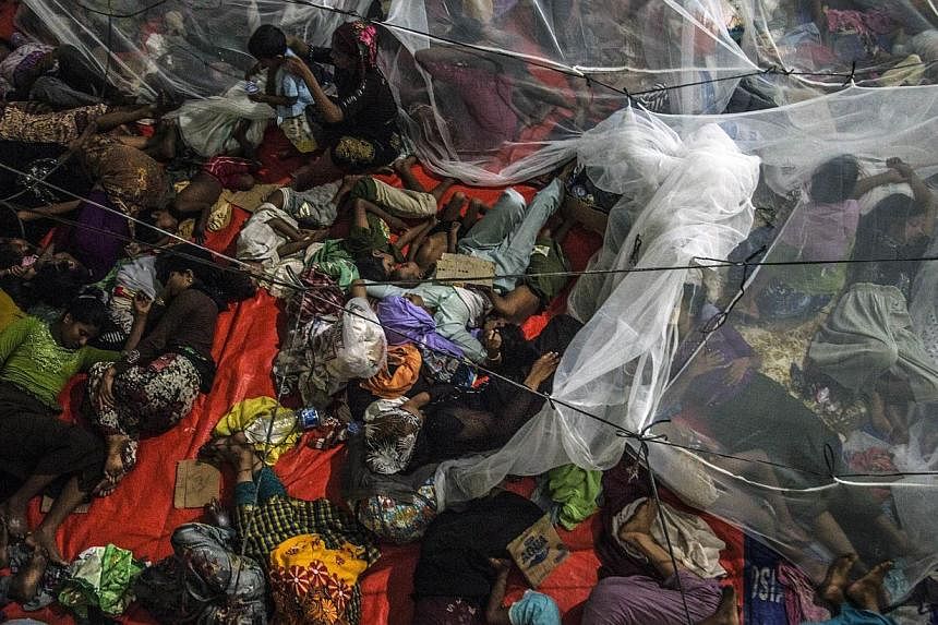Rohingya migrants sleeping at the new confinement area in the fishing town of Kuala Langsa in Aceh province on May 16, 2015 where hundreds of migrants from Myanmar and Bangladesh mostly Rohingyas are taking shelter after they were rescued by Indonesi