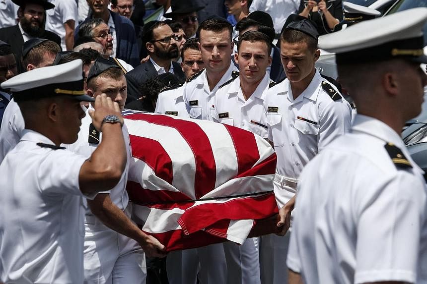 Midshipmen from the US Naval academy carry Midshipman Justin Zemser to a waiting car after his funeral on May 15, 2015 in Hewlett, New York. Zemser was one of eight people killed in the derailment of an Amtrak train on May 12th in Philadelphia. -- PH