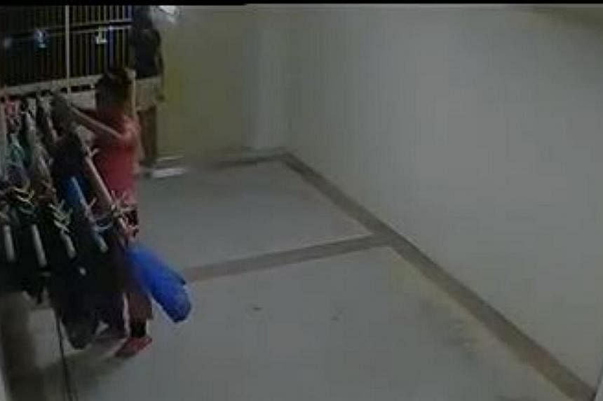A screengrab of CCTV footage showing one girl allegedly stealing from a clothes rack at a Housing Board corridor while another girl acts as a lookout. -- FACEBOOK/ALLSGSTUFF&nbsp;